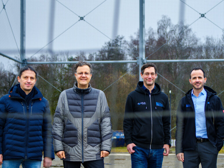 Christian Timmerer, Christian Bettstetter, Stephan Weiss und Jan Steinbrener stehen vor der Drohnenarena im Lakeside Park