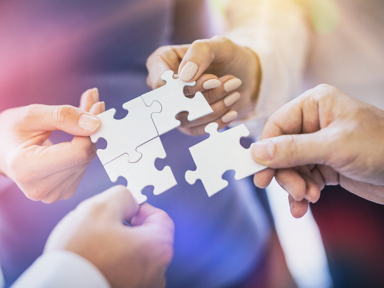 A group of business people assembling jigsaw puzzle. The concept of cooperation, teamwork, help and support in business.