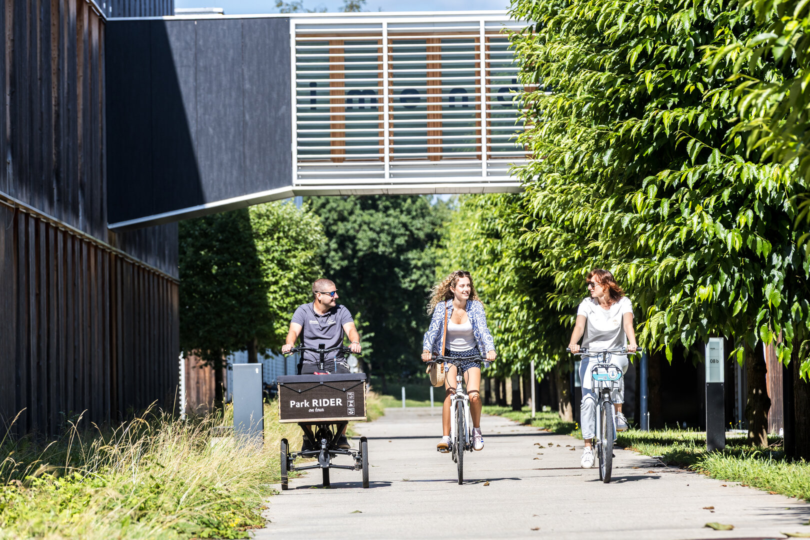 Drei Kolleg:innen radeln durch den Lakeside Park